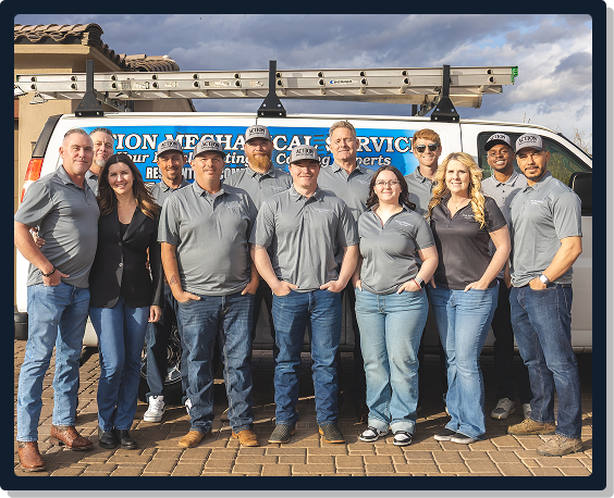 the action mechanical team standing together in front of a work van